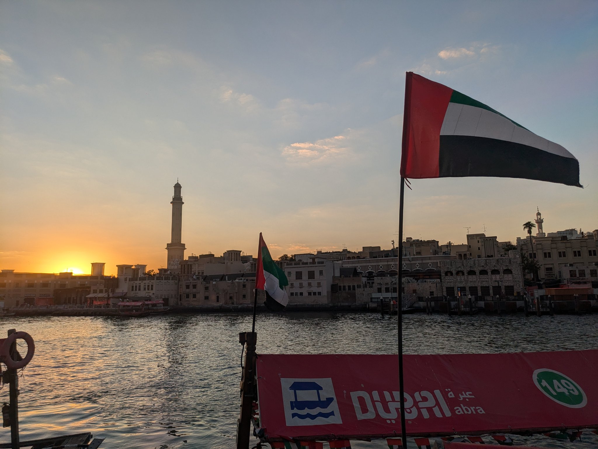 朝日の中のドバイ・クリークと UAE の国旗
