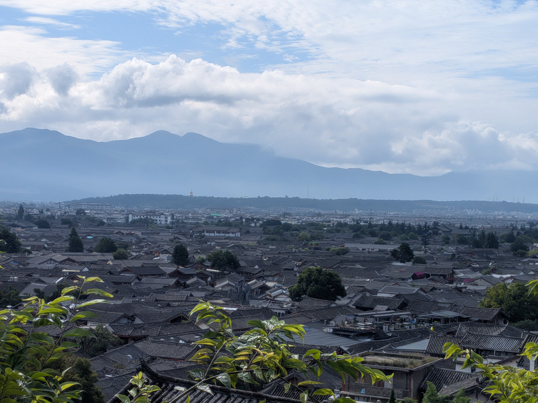 高台から見た晴れた日の麗江古城と山々