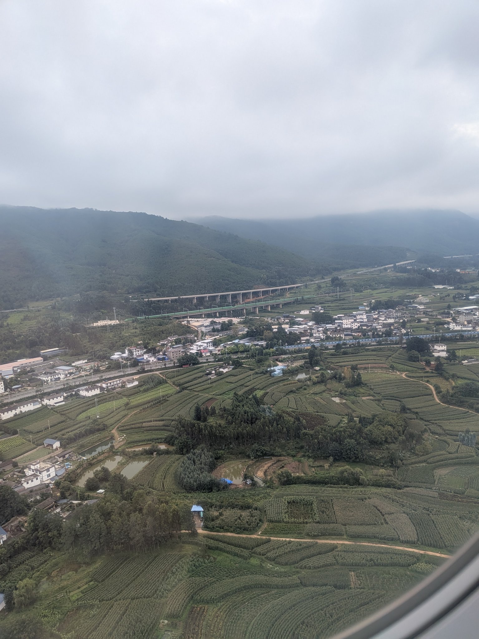 着陸前の飛行機から見た麗江の山あいの景色