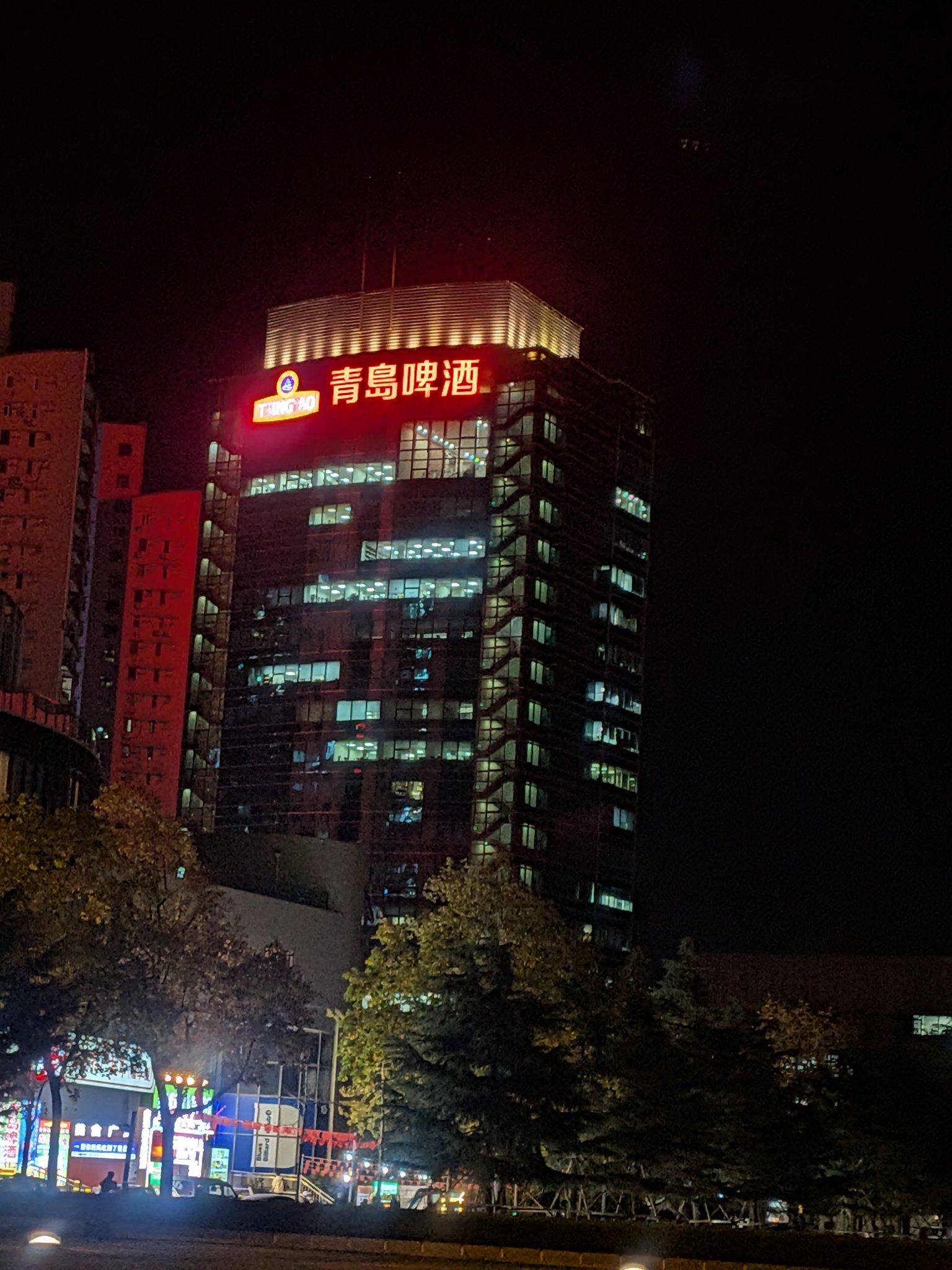青島ビールの看板が光る高層ビル