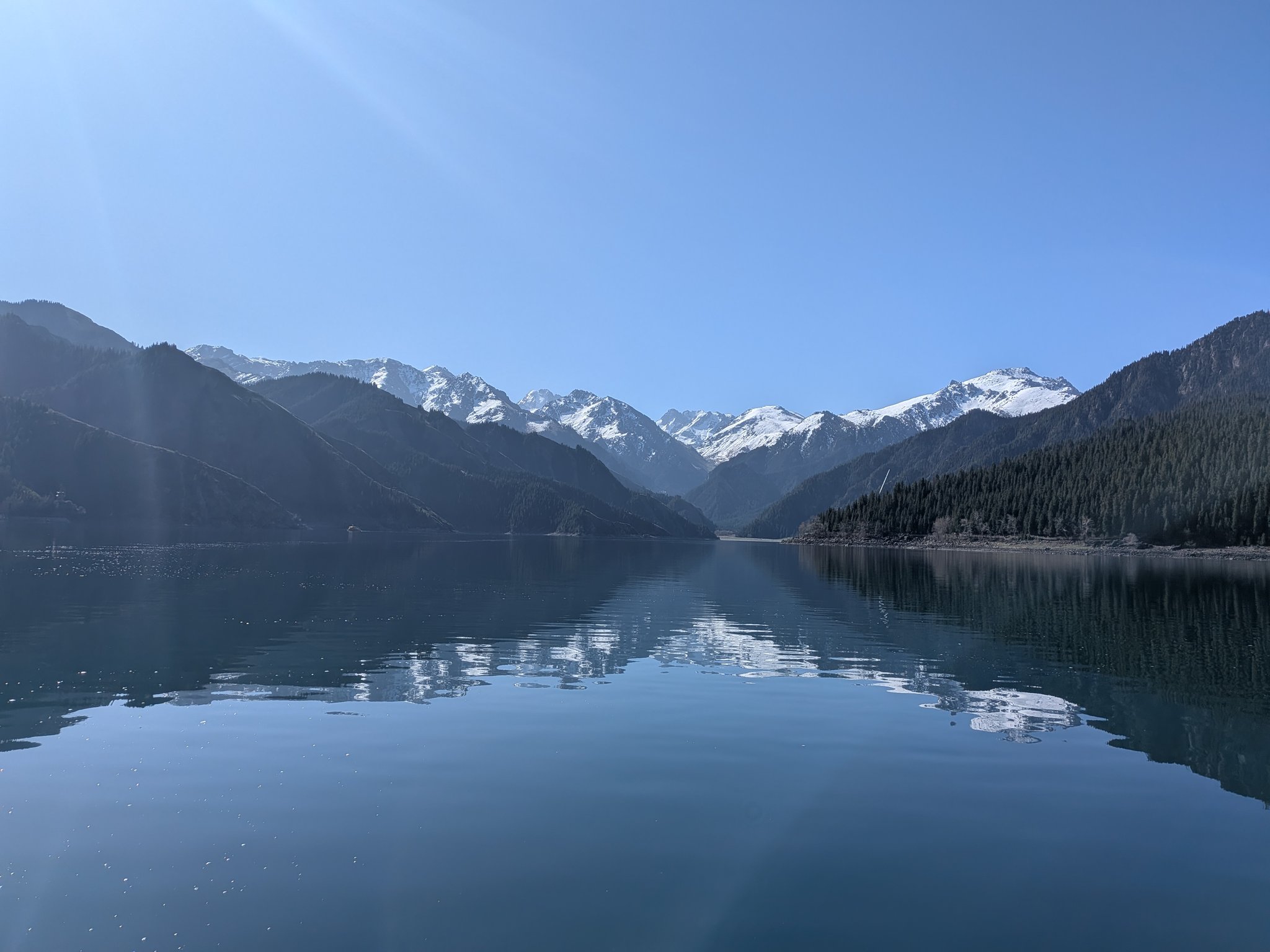 朝の天山天池の湖面に映る山